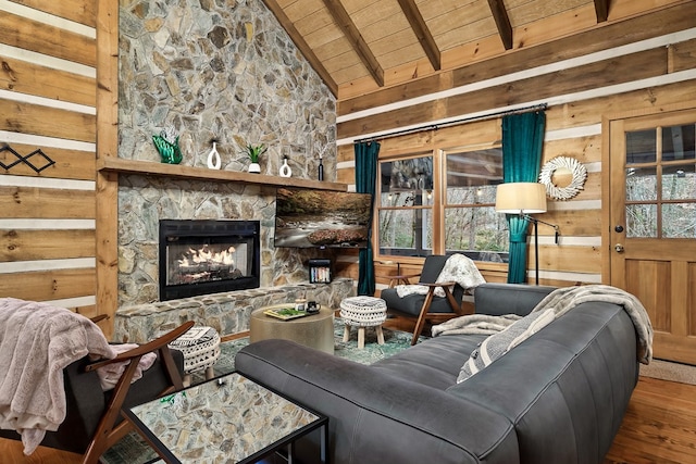 living area with wooden walls, lofted ceiling with beams, wood ceiling, wood finished floors, and a fireplace