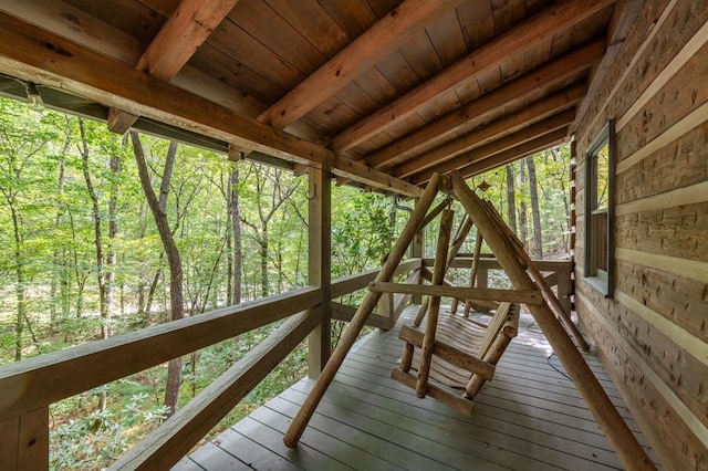 wooden terrace featuring a wooded view