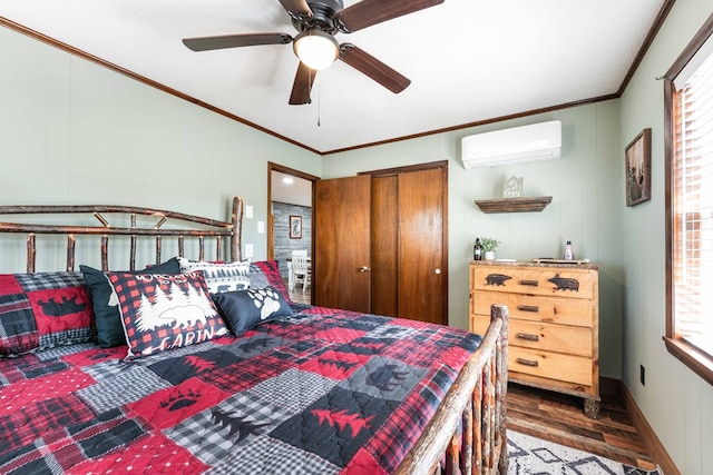 bedroom featuring a closet, baseboards, a wall mounted air conditioner, ornamental molding, and wood finished floors