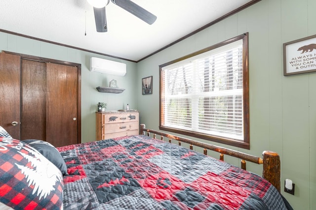 bedroom with crown molding, a decorative wall, a closet, a ceiling fan, and an AC wall unit