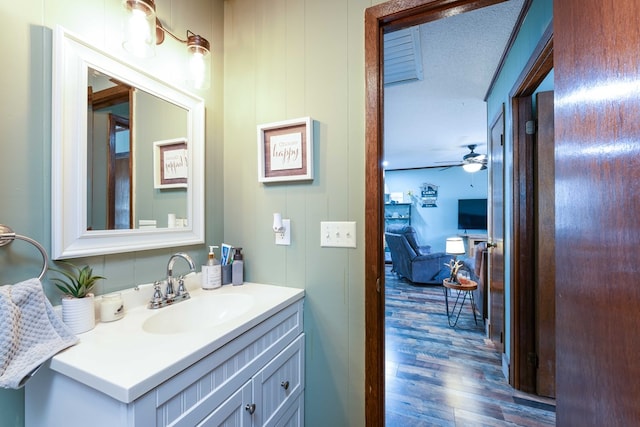bathroom with a ceiling fan, vanity, and wood finished floors
