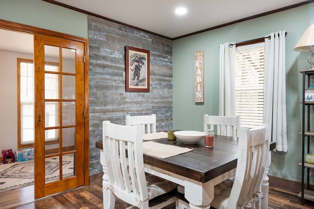 dining room featuring recessed lighting, a textured ceiling, ornamental molding, and wood finished floors