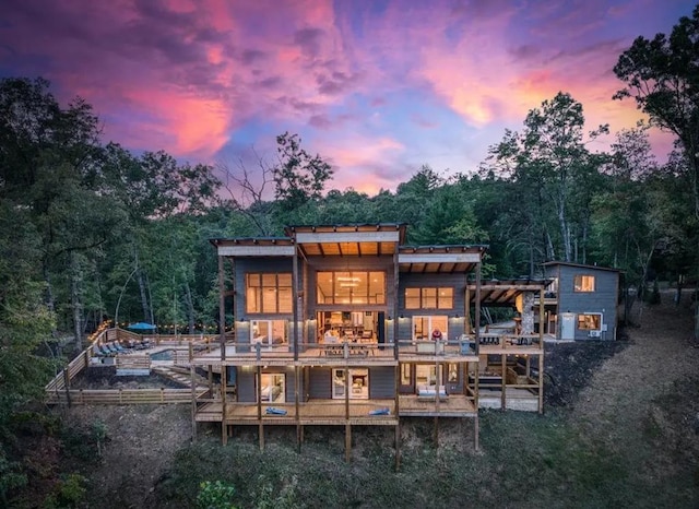 back house at dusk with a balcony