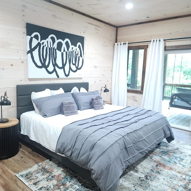 bedroom with wooden walls and wood-type flooring