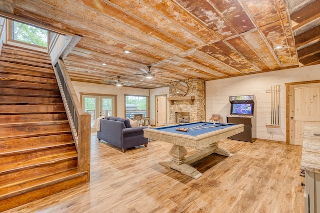 rec room with a fireplace, ceiling fan, pool table, and light wood-type flooring