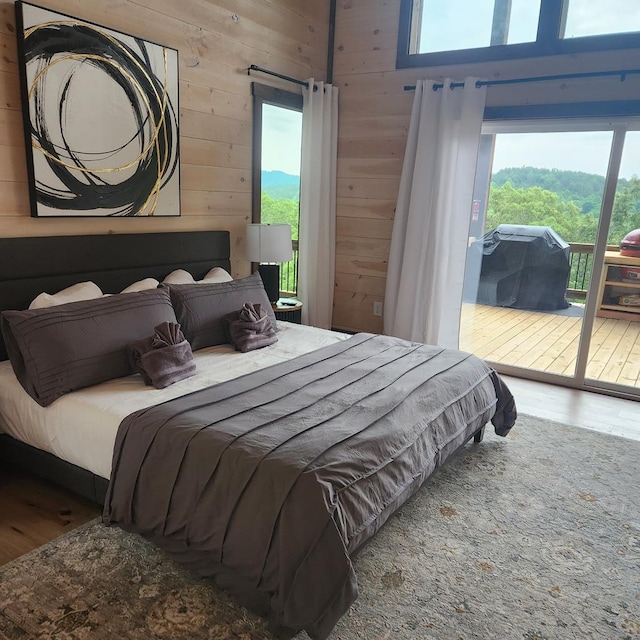 bedroom with hardwood / wood-style floors and wooden walls