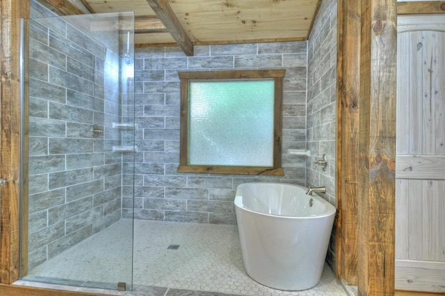 bathroom with beam ceiling, wooden ceiling, tile walls, and plus walk in shower