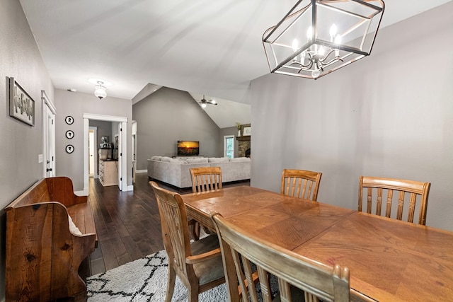135 Adams Farm Dr, Blairsville, GA 30512 - dining space featuring dark wood-style floors, vaulted ceiling, baseboards, a fireplace, and a ceiling fan