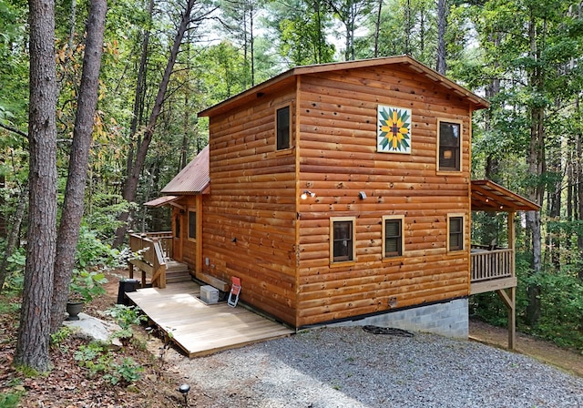 view of side of home with log veneer siding and metal roof