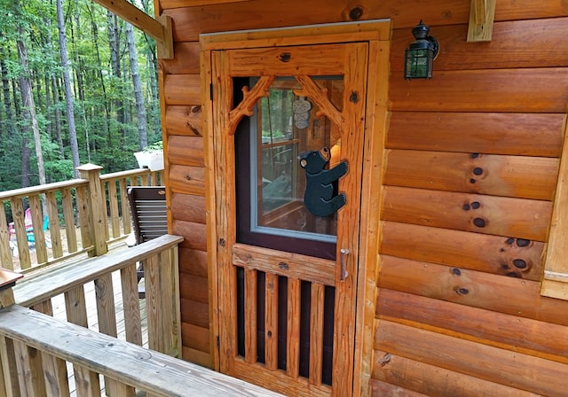 doorway to property featuring faux log siding