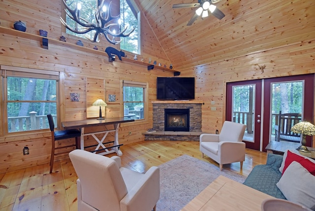 living room with high vaulted ceiling, hardwood / wood-style flooring, wood walls, a fireplace, and wood ceiling