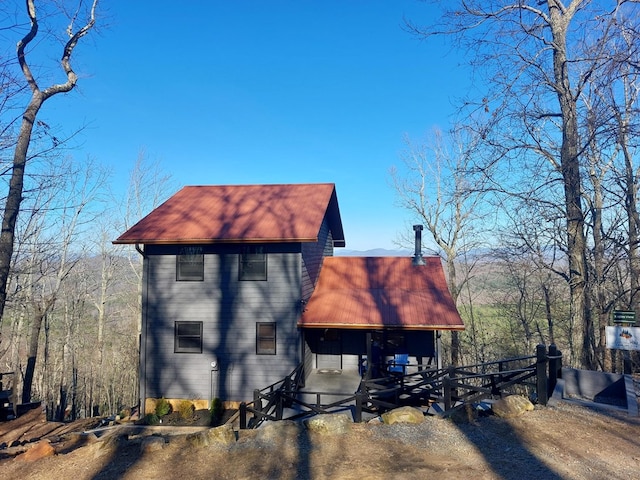 view of home's exterior with dirt driveway and metal roof