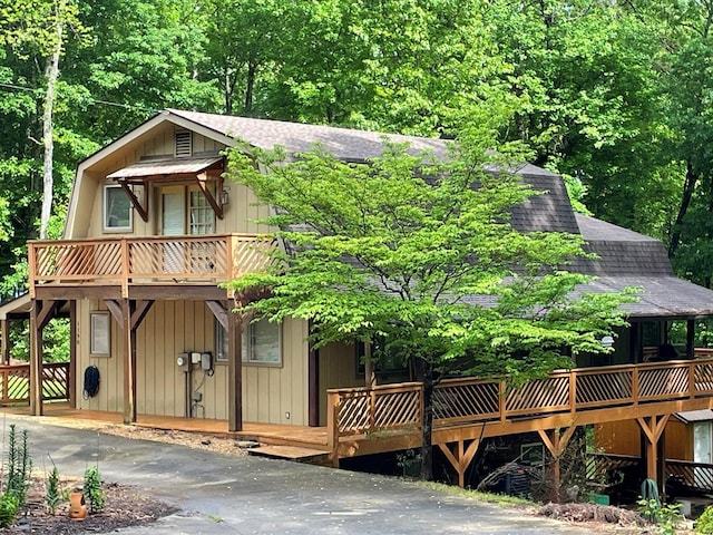 exterior space with a wooden deck and a shingled roof
