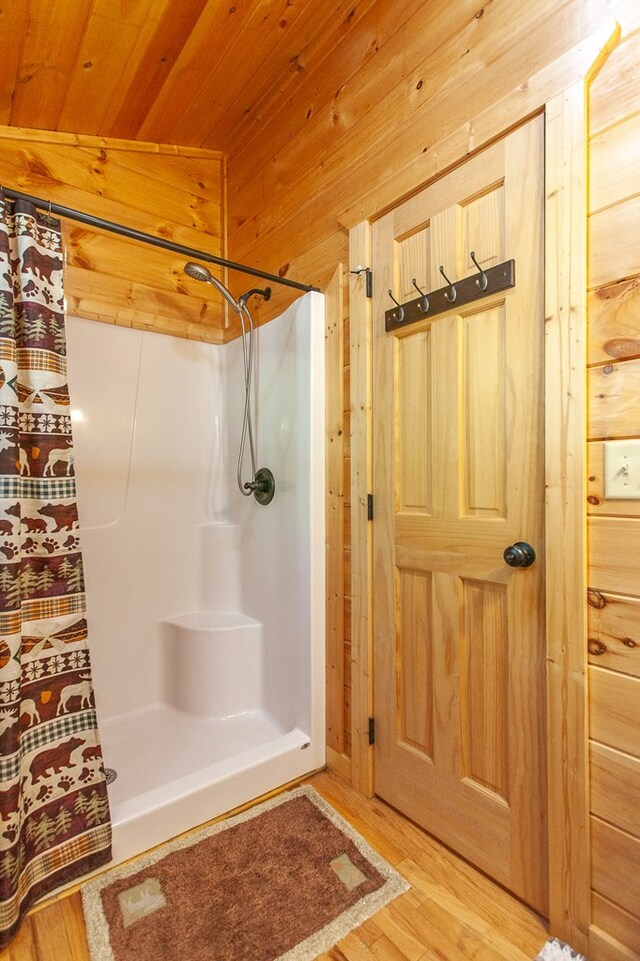 bathroom with curtained shower, wooden walls, wood ceiling, lofted ceiling, and wood-type flooring