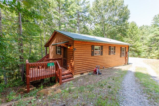 log cabin with a wooden deck