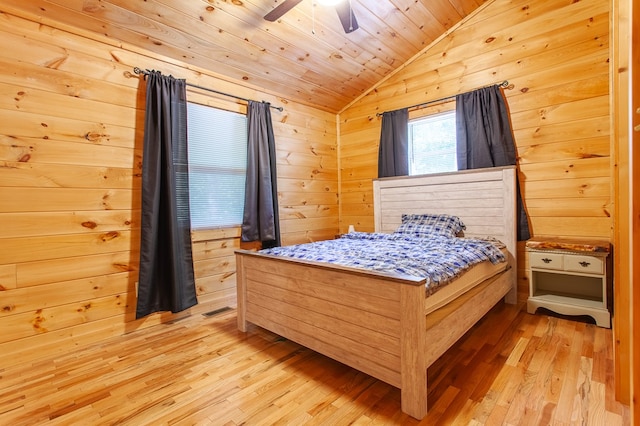 bedroom featuring vaulted ceiling, wood walls, light hardwood / wood-style floors, wood ceiling, and ceiling fan