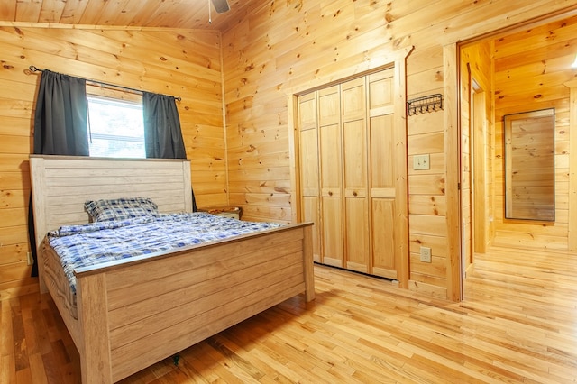 bedroom featuring light wood-type flooring, ceiling fan, wooden walls, and wooden ceiling