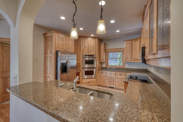 kitchen with sink, hanging light fixtures, stainless steel appliances, kitchen peninsula, and stone countertops