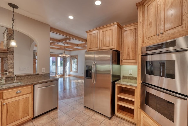 kitchen featuring appliances with stainless steel finishes, light hardwood / wood-style floors, hanging light fixtures, and sink