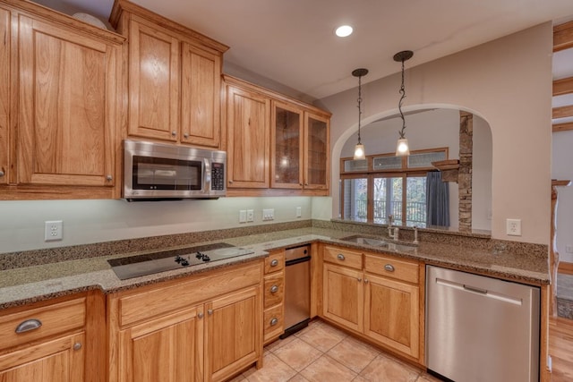 kitchen featuring pendant lighting, sink, light stone counters, kitchen peninsula, and stainless steel appliances