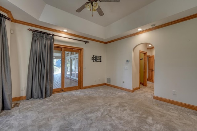 spare room with ceiling fan, crown molding, light carpet, and a tray ceiling