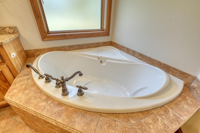 bathroom with tiled bath and vanity