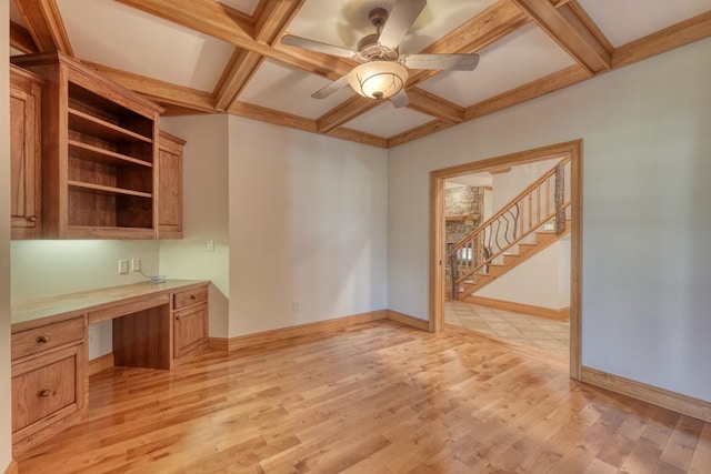 interior space with coffered ceiling, ceiling fan, light wood-type flooring, built in desk, and beamed ceiling