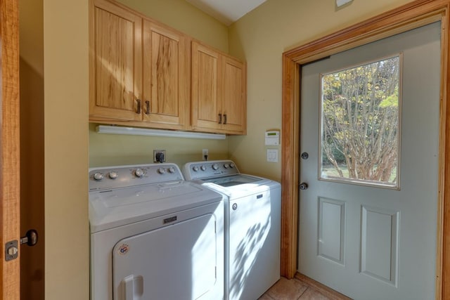 clothes washing area featuring cabinets and separate washer and dryer