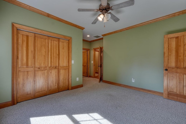 unfurnished bedroom featuring ceiling fan, light colored carpet, crown molding, and a closet