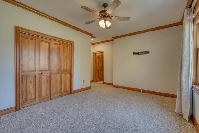 unfurnished bedroom with ceiling fan, a closet, light carpet, and ornamental molding