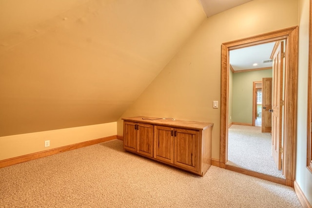 bonus room with light colored carpet and vaulted ceiling