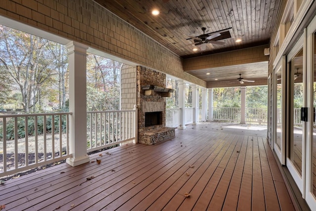 wooden terrace featuring a fireplace and ceiling fan