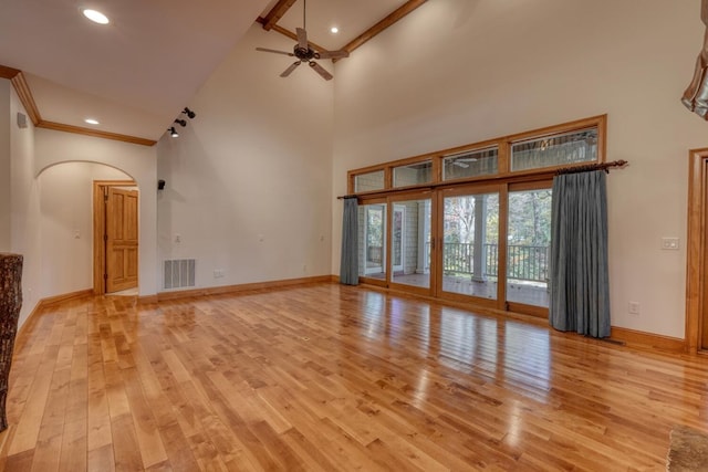 unfurnished living room featuring high vaulted ceiling, light hardwood / wood-style flooring, ceiling fan, and ornamental molding