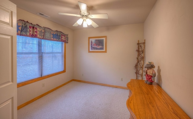 carpeted spare room featuring ceiling fan