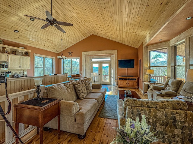 living room featuring french doors, ceiling fan with notable chandelier, vaulted ceiling, hardwood / wood-style flooring, and wooden ceiling