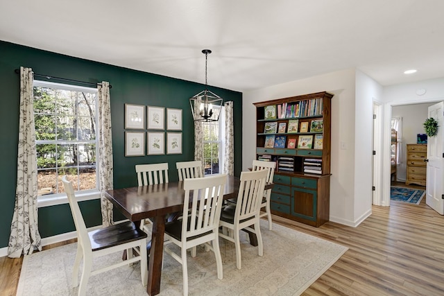 dining space with a chandelier and light hardwood / wood-style floors