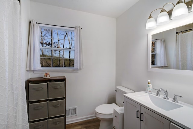 bathroom with toilet, hardwood / wood-style floors, and vanity