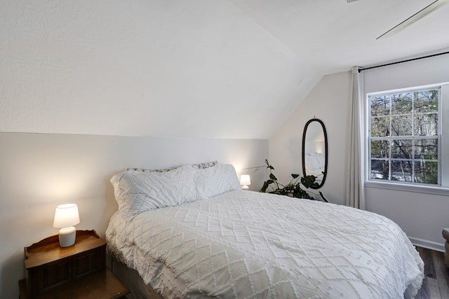 bedroom featuring dark wood-type flooring and lofted ceiling