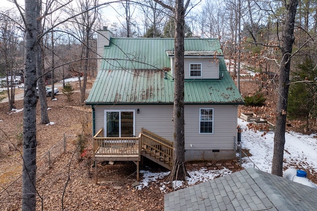 snow covered house with a wooden deck