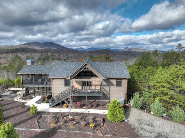 view of front of home featuring a sunroom, a deck with mountain view, and central AC