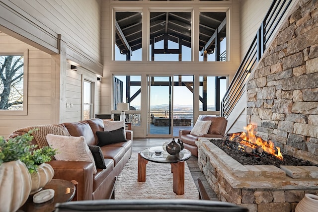 living room with hardwood / wood-style flooring, high vaulted ceiling, and wood walls