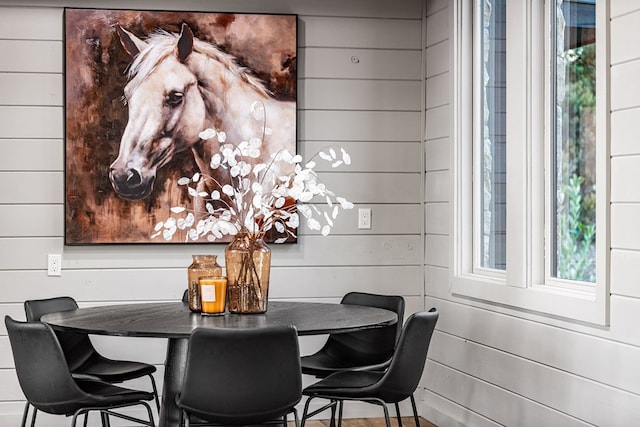 dining area featuring wood walls