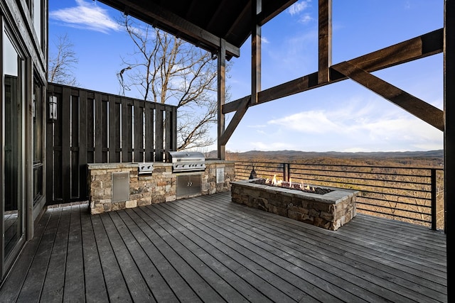 deck featuring area for grilling, an outdoor fire pit, a mountain view, and a grill