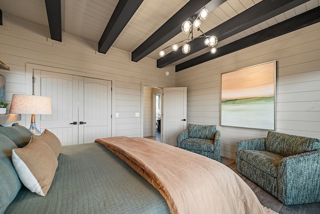 bedroom featuring beamed ceiling, a closet, and wood walls