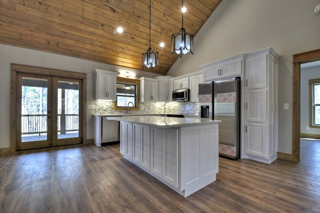 kitchen featuring backsplash, a kitchen island, french doors, white cabinets, and stainless steel appliances