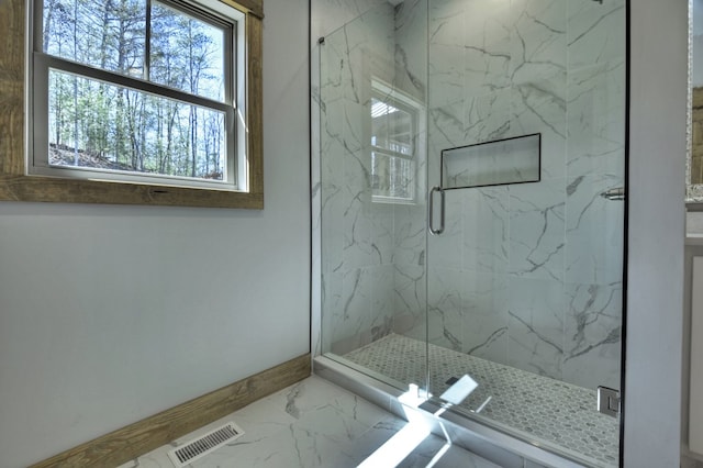 bathroom with a marble finish shower, visible vents, marble finish floor, and baseboards