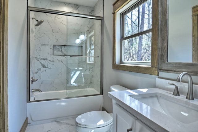 full bath featuring plenty of natural light, toilet, marble finish floor, and vanity