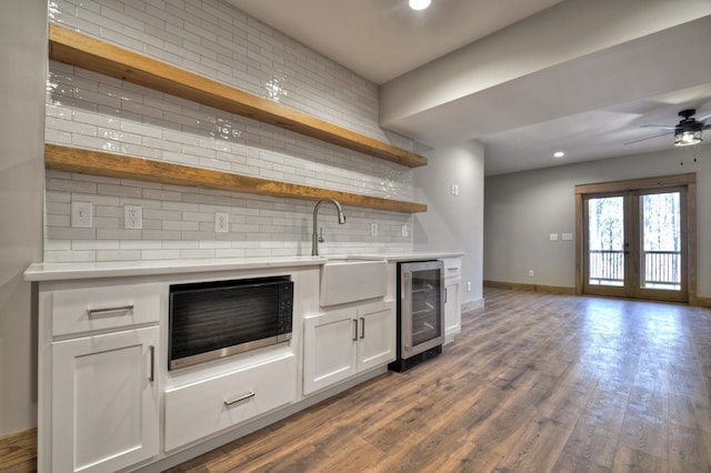 kitchen with open shelves, light countertops, wine cooler, dark wood-type flooring, and black microwave