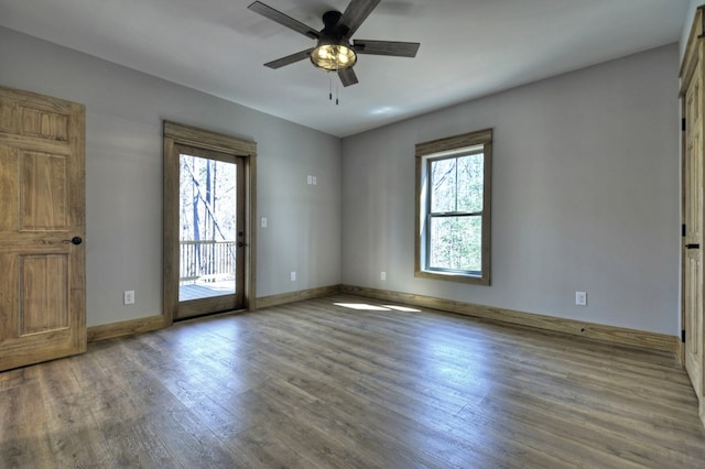 empty room featuring baseboards, a ceiling fan, and wood finished floors