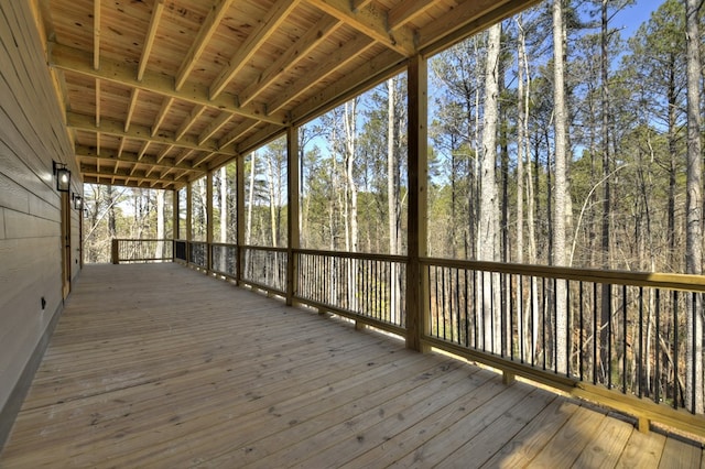 wooden terrace featuring a forest view